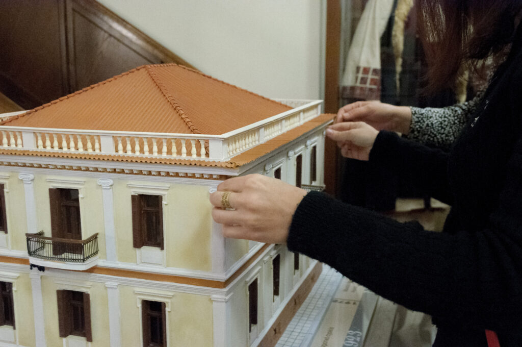 Χέρια ψηλαφίζουν μακέτα του κτηρίου του Μουσείου Μακεδονικού Αγώνα.